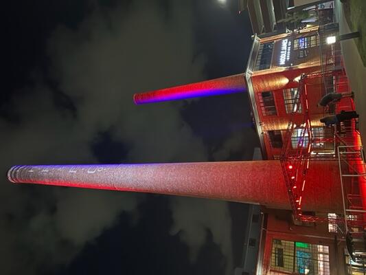 The Power House Apartments illuminated smokestacks glowing at night in downtown Rock Hill, SC