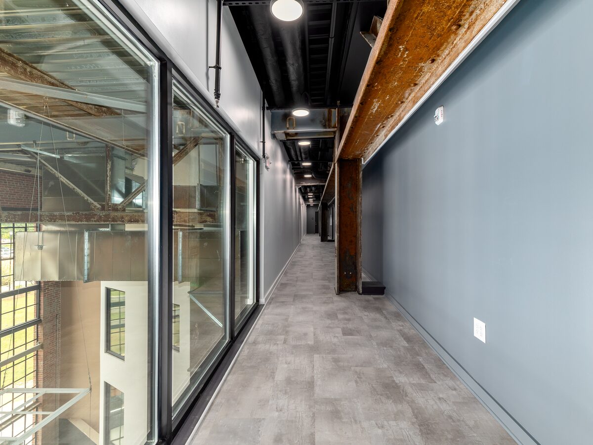 Interior atrium corridor with exposed brick and factory windows inside The Power House — a restored 1920s power plant in Rock Hill, SC